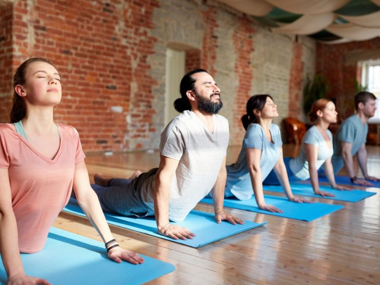5 Menschen machen zusammen Yoga und die Sonne scheint | yoga report