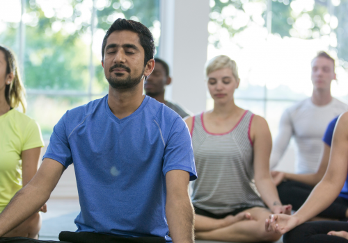 Eine Gruppe von Männern und Frauen, die Yoga praktizieren