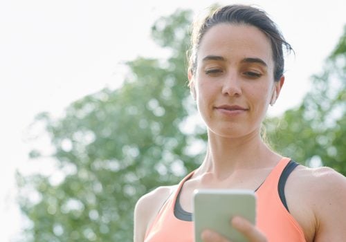 Frau mit ihrem Smartphone setzt Tipps für Yoga Social Media um